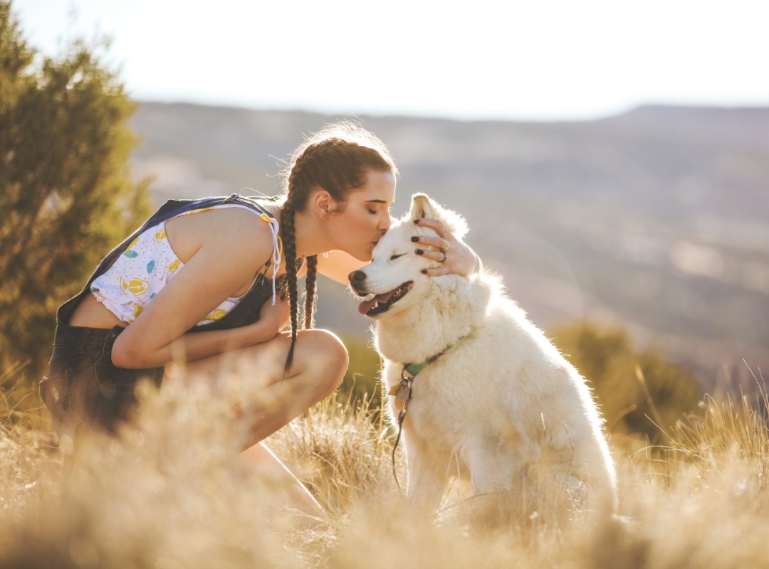 A woman kissing a dog